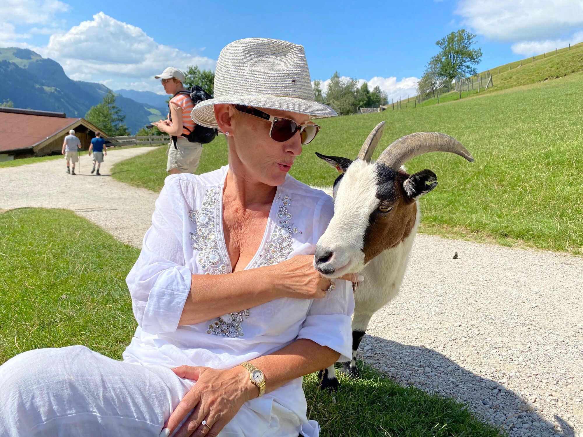 Evdokia Kulikova in Weiß mit einer Bergziege in alpiner Landschaft, Archivfoto