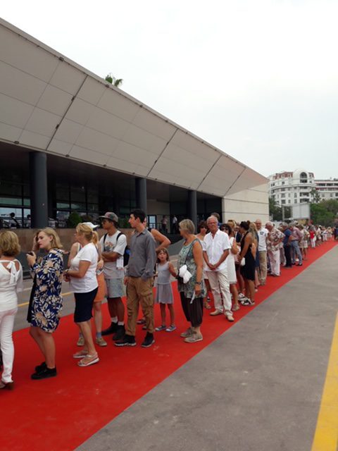 Besucherschlange auf rotem Teppich vor einer Ausstellungshalle