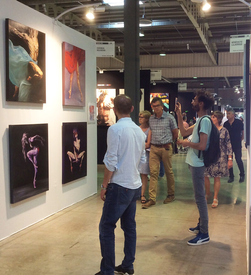 Besucher betrachten die Ausstellungswand mit Tänzerinnen-Serie