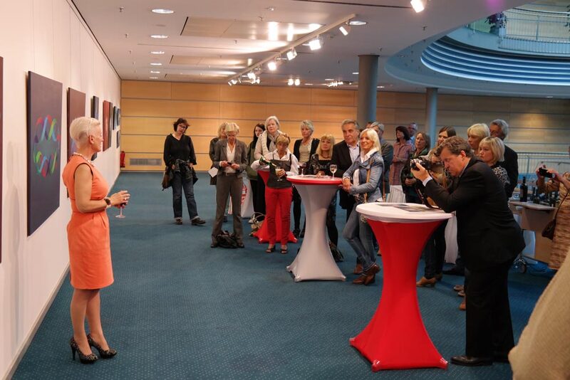 Empfang mit Stehtischen vor der Ausstellungswand