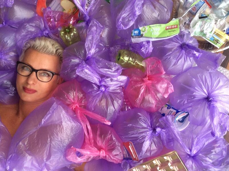 Portraitszene zwischen rosa Plastiksäcken mit Geldscheinen