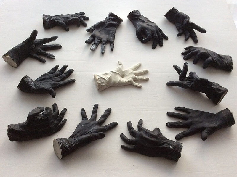 Kreis aus schwarzen Handschuhen um ein weißes Paar, Objektkomposition