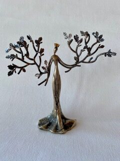 Bronzefarbene Frauenfigur als Baum mit Blütenzweigen