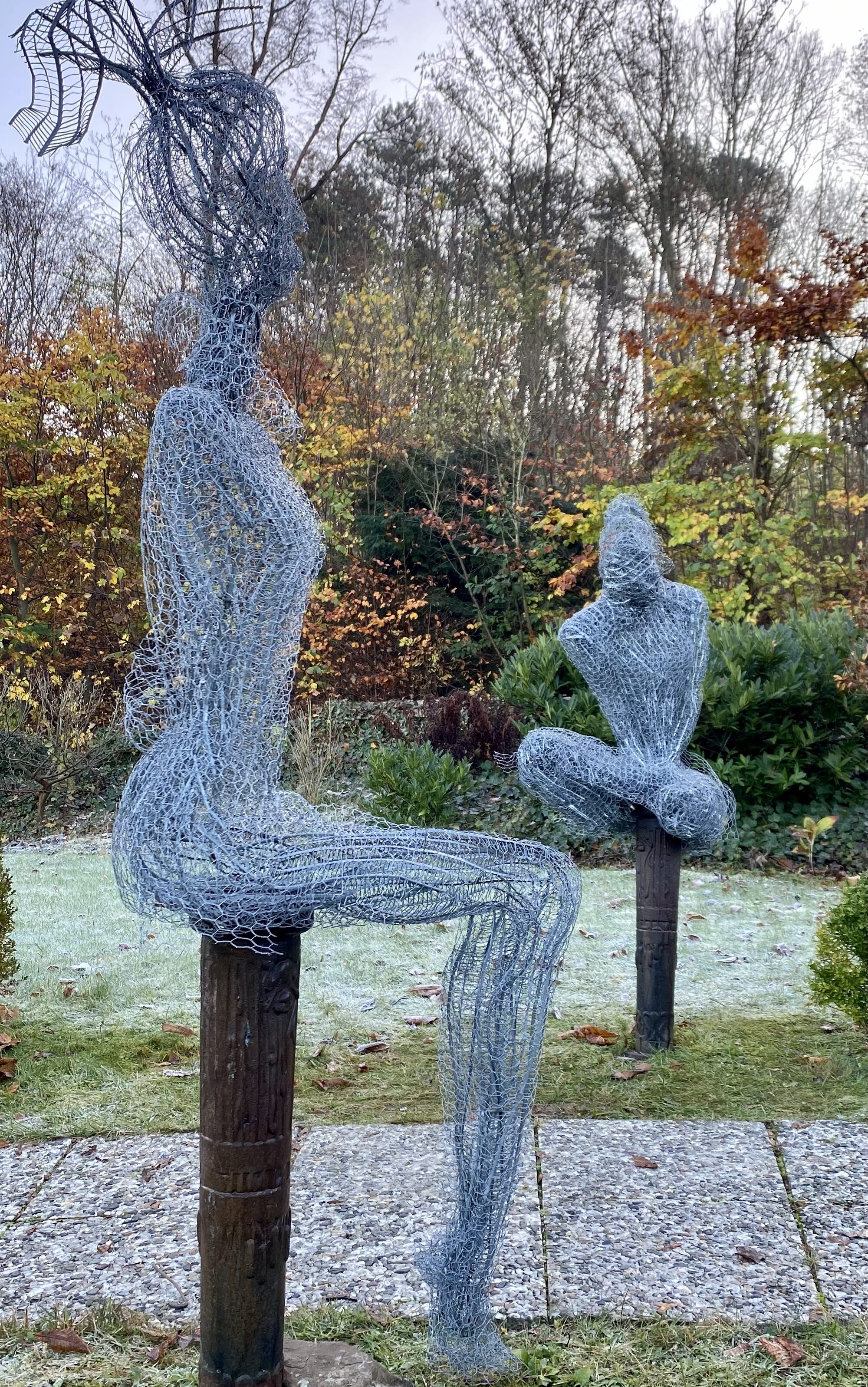 Zwei sitzende Drahtfiguren im Garten, Gesamtansicht des Ensembles