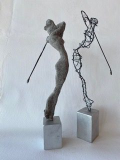Zwei Golfspieler-Drahtfiguren auf Betonsockeln