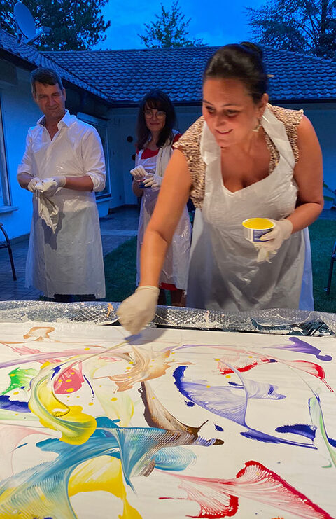 Teilnehmerinnen malen an Leinwänden während eines Art-Workshops